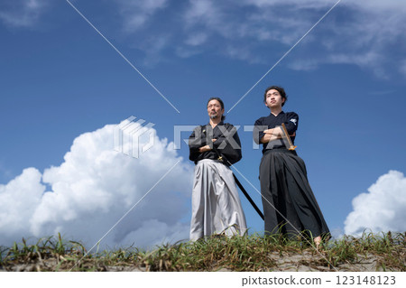 一位身著和服的老人和一位年輕人交叉雙臂站著 123148123