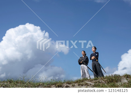 An old man and a young man in kimono standing with their arms folded 123148125