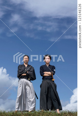 一位身著和服的老人和一位年輕人交叉雙臂站著 123148126