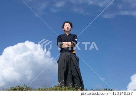 藍天下,身穿劍道服的男子閉上雙眼,雙手交叉 藍天下,身穿劍道服的男子閉上雙眼,雙手交叉 123148127