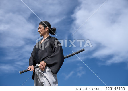 A middle-aged man in kimono standing with a sword A middle-aged man in kimono standing with a sword 123148133