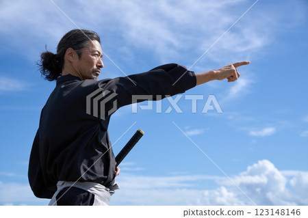 一名身穿和服的中年男子手持劍,指向遠方 一名身穿和服的中年男子手持劍,指向遠方 123148146