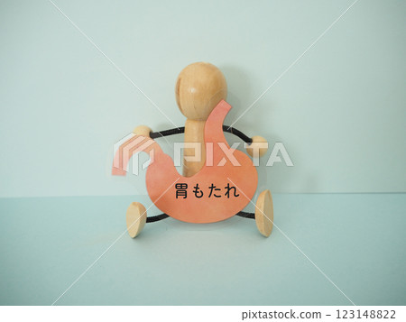 The doll is holding a stomach with the words "upset stomach" written on it The doll is holding a stomach with the words "upset stomach" written on it 123148822