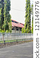 Greenery enhances this tranquil area with tall trees by a fence near a house, providing a peaceful suburban aesthetic surrounded by nature. 123149776