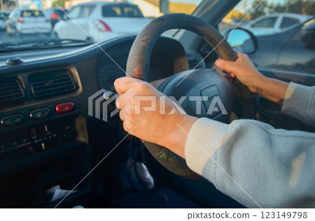 Hands on Steering Wheel in Traffic at Sunset Hands on Steering Wheel in Traffic at Sunset 123149798