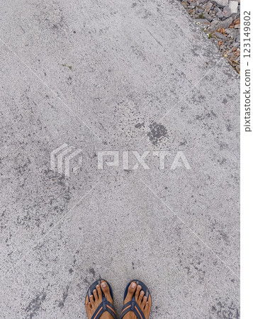 Cement road. Foot can be seen on a cement road. Grey road. Cement road. Foot can be seen on a cement road. Grey road. 123149802