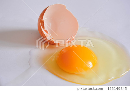 Cracked Egg with Yolk and Shell on White Background marco shot  123149845