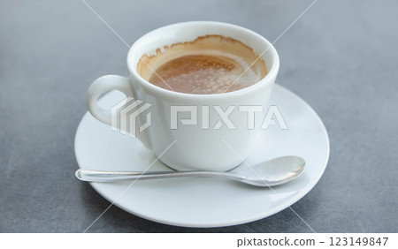 Freshly Brewed Espresso in a White Ceramic Cup on grey ash background  123149847