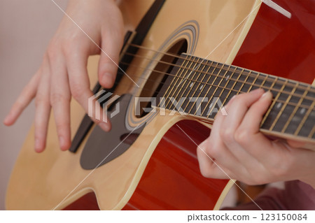 Woman guitarist is practicing of playing classical six string acoustic guitar 123150084
