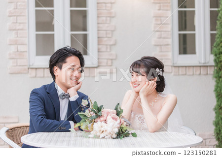 Bride and groom taking photos with bouquet in the garden of the wedding venue at the wedding ceremony (Garden wedding) Bride and groom taking photos with bouquet in the garden of the wedding venue at the wedding ceremony (Garden wedding) 123150281