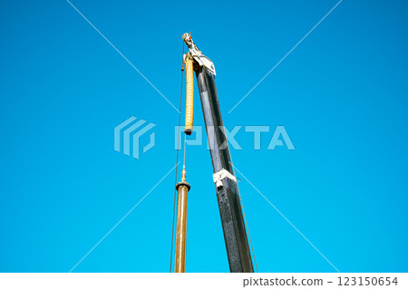 Heavy machinery arms stretching into the blue sky, light color 123150654