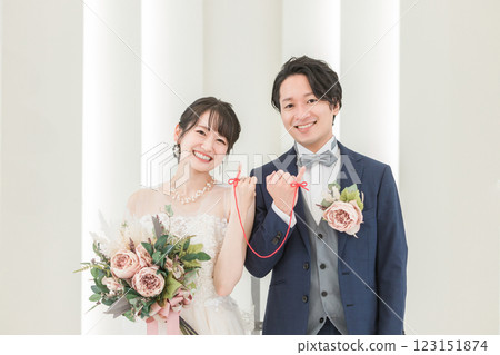 A bride and groom tied with a red thread at a wedding hall (bridal wedding) A bride and groom tied with a red thread at a wedding hall (bridal wedding) 123151874