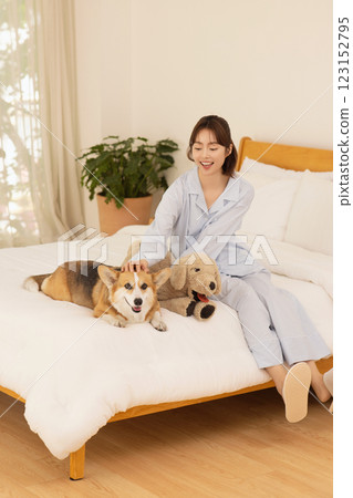 Side view of woman sitting on bed with dog 123152795