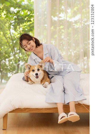 Side view of woman sitting on bed with dog Side view of woman sitting on bed with dog 123152804