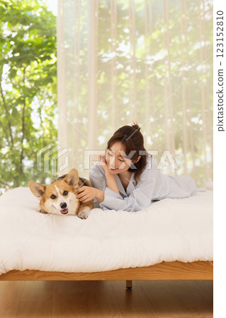 Side view of woman lying in bed with dog Side view of woman lying in bed with dog 123152810