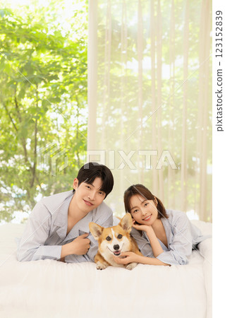 Portrait of young couple lying in bed with dog 123152839