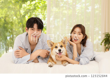 Portrait of young couple lying in bed with dog Portrait of young couple lying in bed with dog 123152844