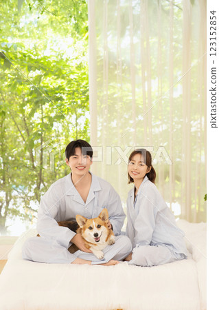 Cropped view of young couple sitting on bed with dog 123152854