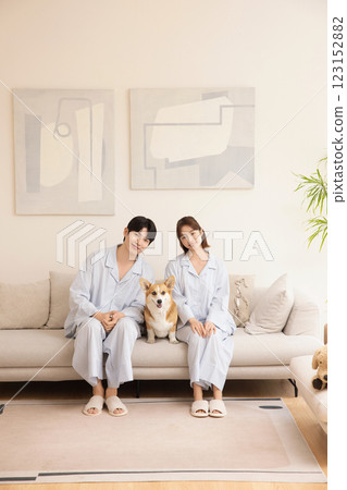 A young couple sitting on a sofa and resting with their dog A young couple sitting on a sofa and resting with their dog 123152882