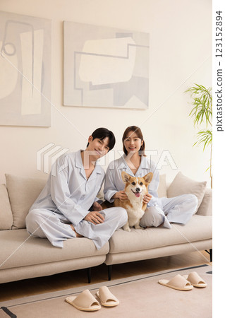 A young couple sitting on a sofa and resting with their dog A young couple sitting on a sofa and resting with their dog 123152894