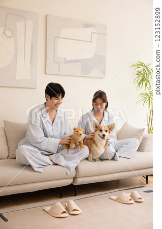 A young couple sitting on a sofa and resting with their dog 123152899