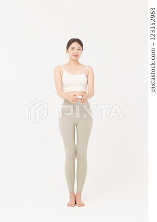 Cropped view of young woman measuring waist circumference wearing sportswear 123152963
