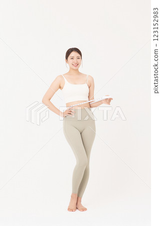 Cropped view of young woman measuring waist circumference wearing sportswear 123152983