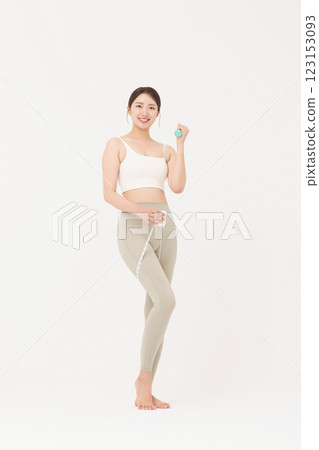 Cropped view of young woman wearing sportswear measuring leg circumference 123153093