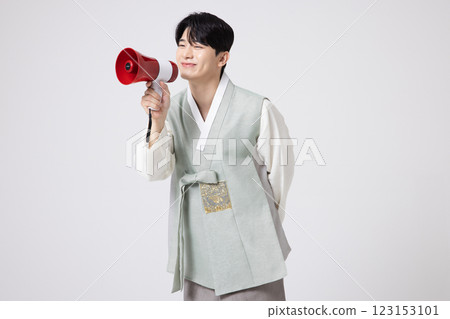 A young man wearing a hanbok and shouting while holding a megaphone 123153101