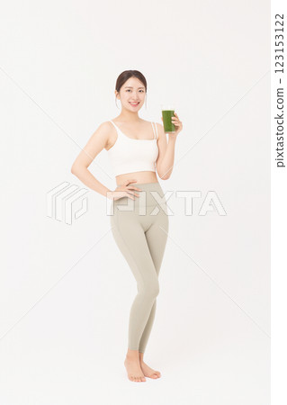 Cropped view of young woman wearing sportswear and drinking healthy drink Cropped view of young woman wearing sportswear and drinking healthy drink 123153122