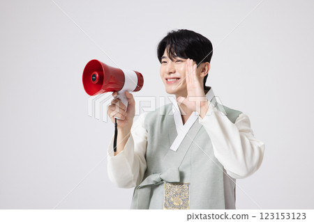 A young man wearing a hanbok and shouting while holding a megaphone A young man wearing a hanbok and shouting while holding a megaphone 123153123