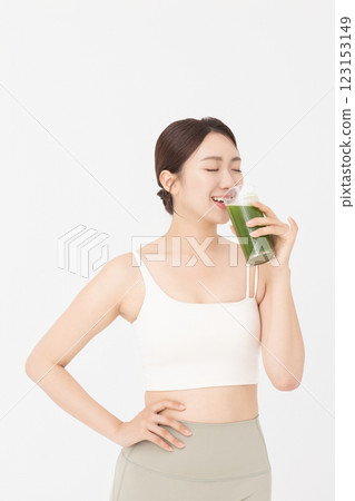 Cropped view of young woman wearing sportswear and drinking healthy drink 123153149