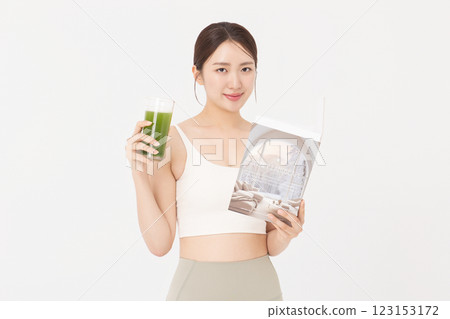 Portrait of young woman wearing sportswear, drinking healthy drink and reading book Portrait of young woman wearing sportswear, drinking healthy drink and reading book 123153172