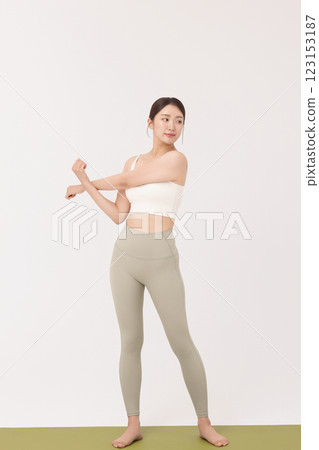 Portrait of a young woman wearing sportswear and stretching on a yoga mat Portrait of a young woman wearing sportswear and stretching on a yoga mat 123153187