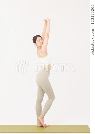 Portrait of a young woman wearing sportswear and stretching on a yoga mat Portrait of a young woman wearing sportswear and stretching on a yoga mat 123153206