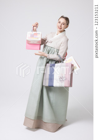 A Western woman standing wearing a Hanbok and holding shopping bags A Western woman standing wearing a Hanbok and holding shopping bags 123153211