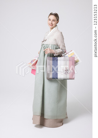 A Western woman standing wearing a Hanbok and holding shopping bags A Western woman standing wearing a Hanbok and holding shopping bags 123153213