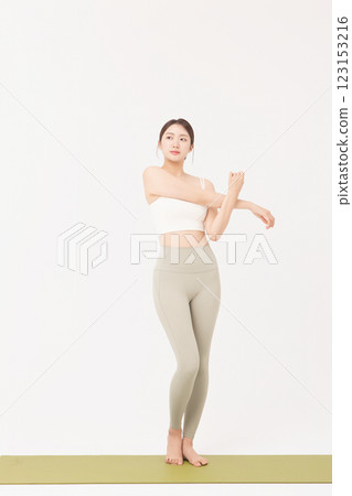 Portrait of a young woman wearing sportswear and stretching on a yoga mat Portrait of a young woman wearing sportswear and stretching on a yoga mat 123153216