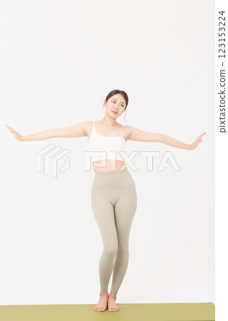Portrait of a young woman wearing sportswear and stretching on a yoga mat Portrait of a young woman wearing sportswear and stretching on a yoga mat 123153224