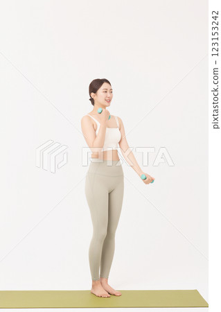 Portrait of a young woman doing bodyweight exercises while holding dumbbells Portrait of a young woman doing bodyweight exercises while holding dumbbells 123153242