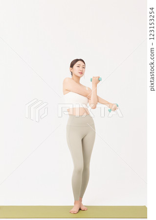 Portrait of a young woman doing bodyweight exercises while holding dumbbells Portrait of a young woman doing bodyweight exercises while holding dumbbells 123153254