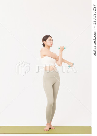 Portrait of a young woman doing bodyweight exercises while holding dumbbells Portrait of a young woman doing bodyweight exercises while holding dumbbells 123153257