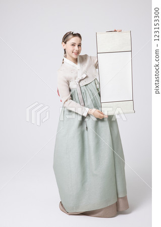 A Western woman standing wearing a Hanbok and holding a hanging scroll A Western woman standing wearing a Hanbok and holding a hanging scroll 123153300