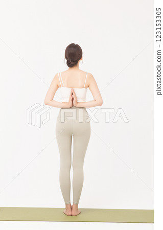 Portrait of a young woman wearing sportswear and stretching on a yoga mat Portrait of a young woman wearing sportswear and stretching on a yoga mat 123153305