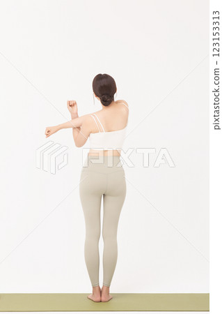 Portrait of a young woman wearing sportswear and stretching on a yoga mat Portrait of a young woman wearing sportswear and stretching on a yoga mat 123153313