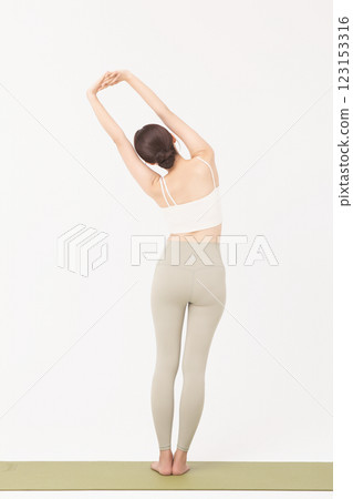 Portrait of a young woman wearing sportswear and stretching on a yoga mat Portrait of a young woman wearing sportswear and stretching on a yoga mat 123153316