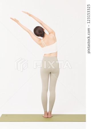 Portrait of a young woman wearing sportswear and stretching on a yoga mat Portrait of a young woman wearing sportswear and stretching on a yoga mat 123153325