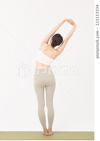 Portrait of a young woman wearing sportswear and stretching on a yoga mat Portrait of a young woman wearing sportswear and stretching on a yoga mat 123153334