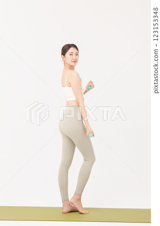 Portrait of a young woman doing bodyweight exercises while holding dumbbells Portrait of a young woman doing bodyweight exercises while holding dumbbells 123153348