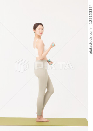 Portrait of a young woman doing bodyweight exercises while holding dumbbells Portrait of a young woman doing bodyweight exercises while holding dumbbells 123153354